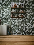 a room with a wooden floor and a wall with plants on it