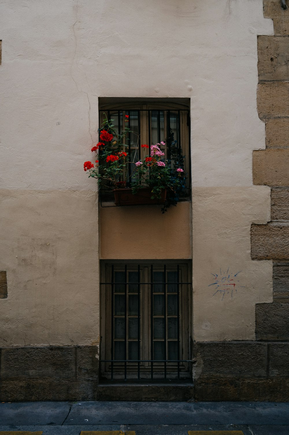 a building with a window and a planter with flowers