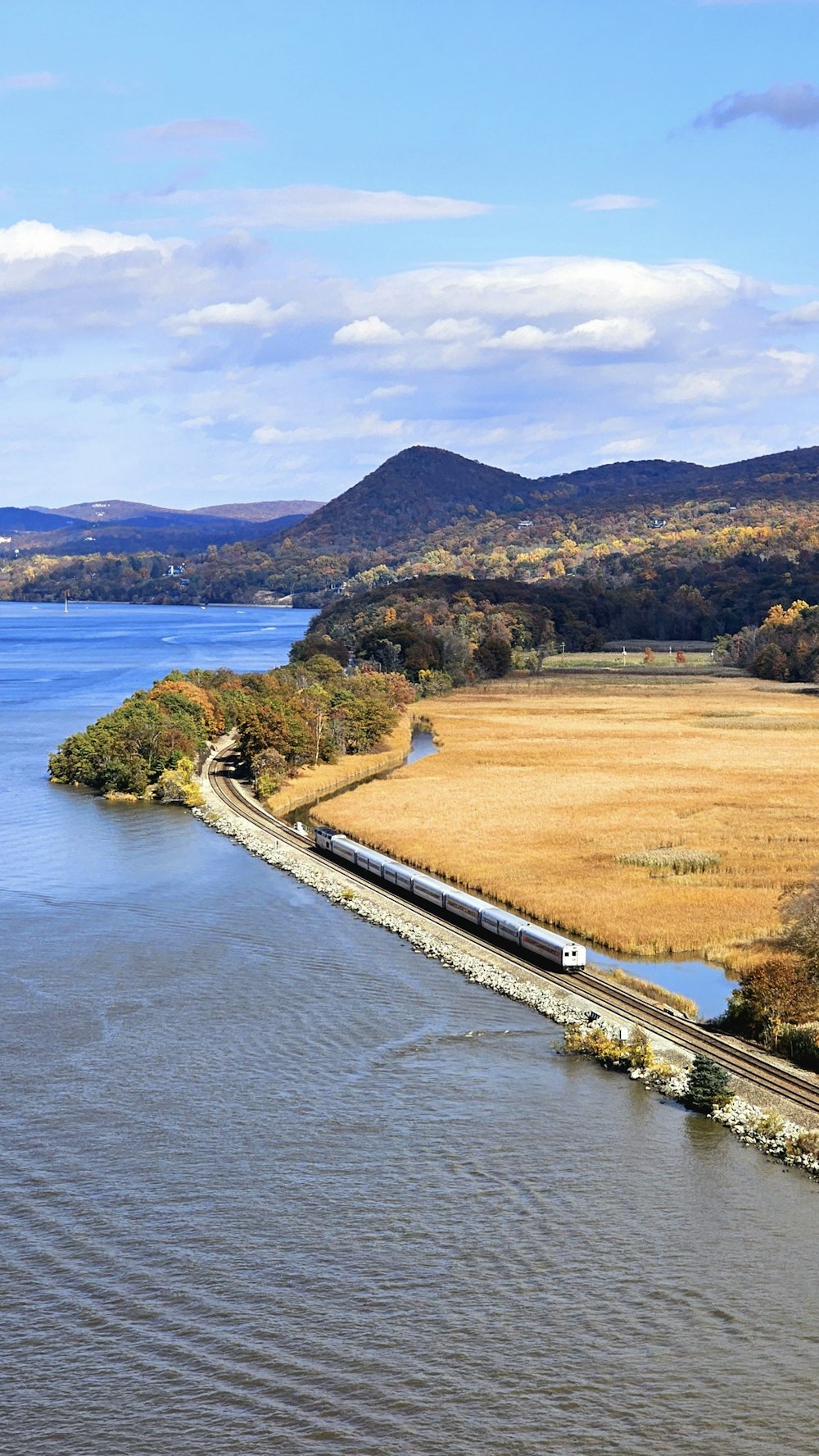 a train traveling down tracks next to a body of water