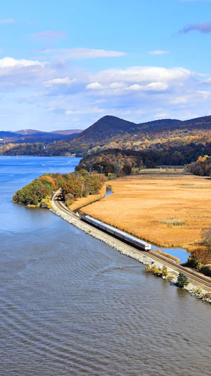 A passenger train travelling beside water