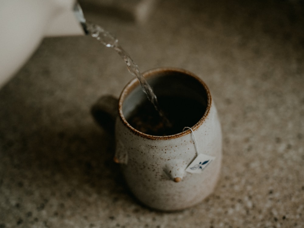 a cup of coffee is being filled with water