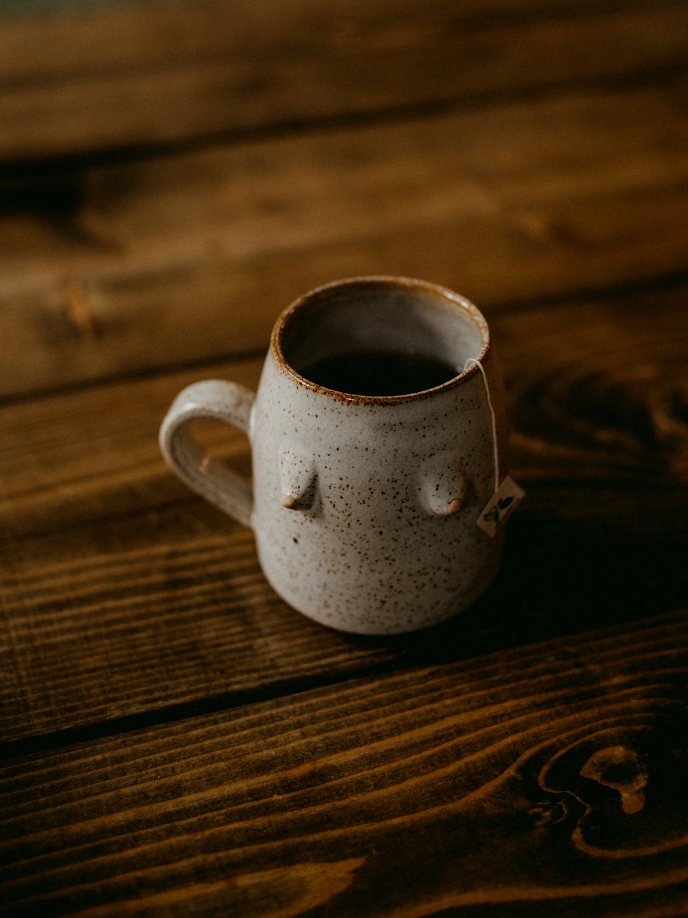 a cup of coffee sitting on top of a wooden table