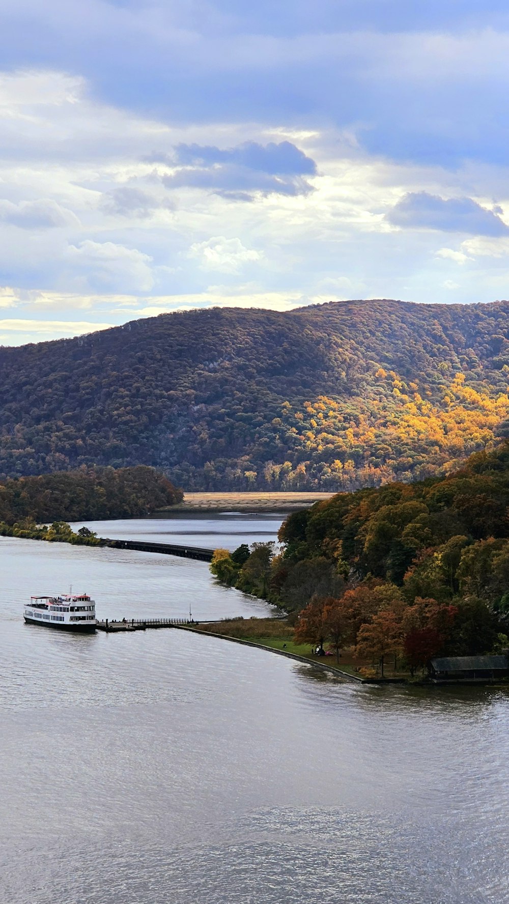 a boat traveling down a river surrounded by mountains