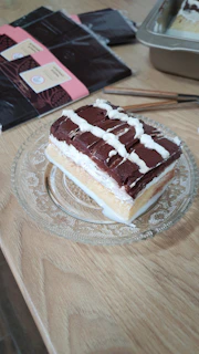 Elegant slice of a layered dessert featuring smooth cream textures and subtle matte gold highlights.