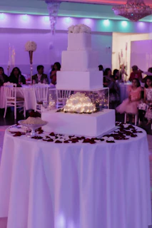 Close-up of the illuminated wedding cake under vibrant party lights.