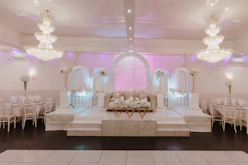 Elegant wedding setup with soft uplighting and gold accents in the grand party hall.
