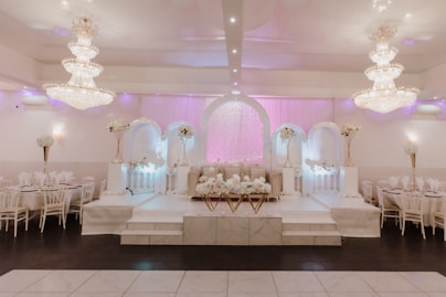 Spacious decorated event hall with elegant lighting and seating arrangements.