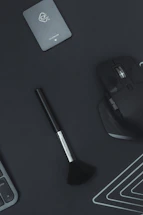 A sleek, dark-themed workspace with leather accessories and elegant shadows.