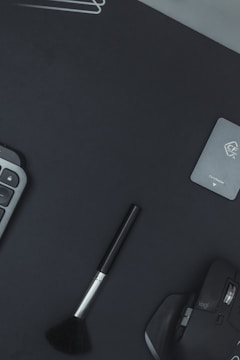 A stylish workspace featuring branding materials like logos, business cards, and color swatches arranged neatly on a dark surface.