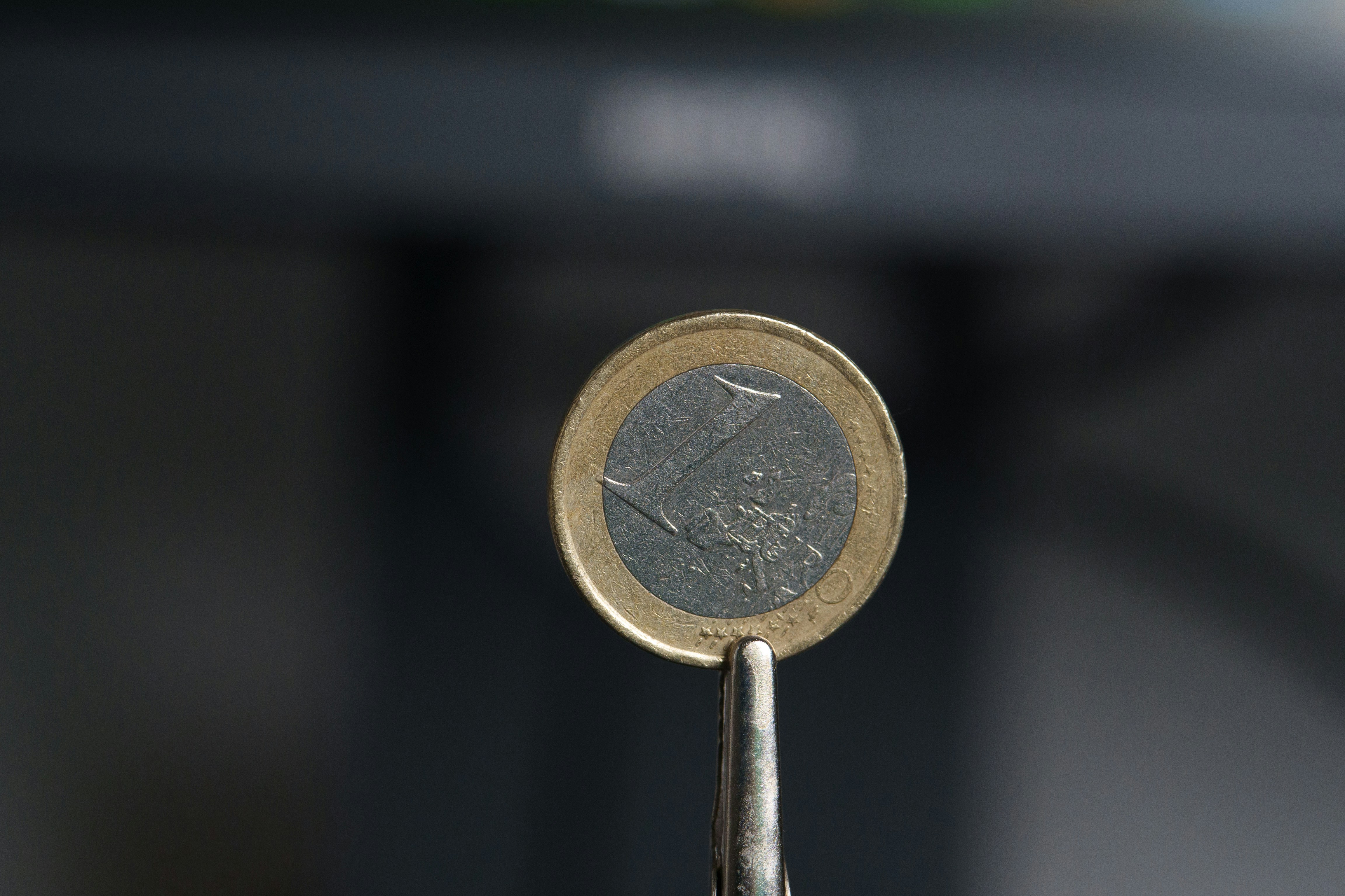 A close-up shot of a magnifying glass held over a single coin on a clean surface, highlighting the importance of focusing on revenue-generating metrics.