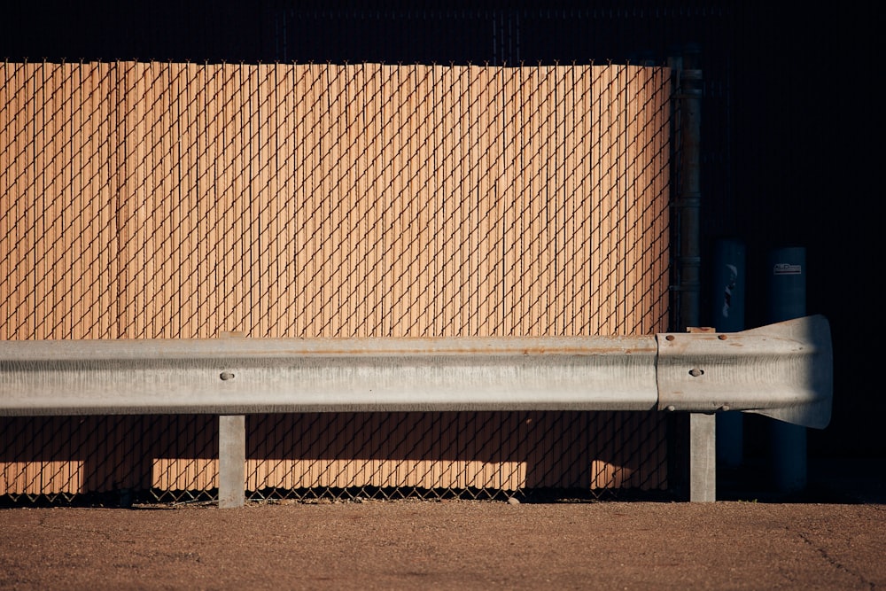 a metal bench sitting in front of a wall