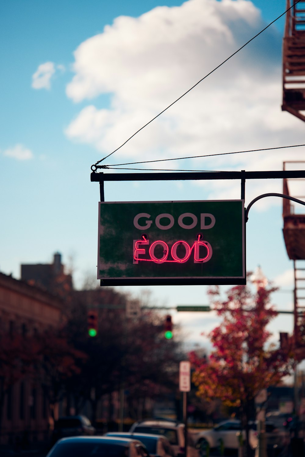 a good food sign hanging from the side of a building