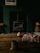 A cozy scene with a colorful handmade stoneware mug resting on a wooden table beside a softly glowing candle.