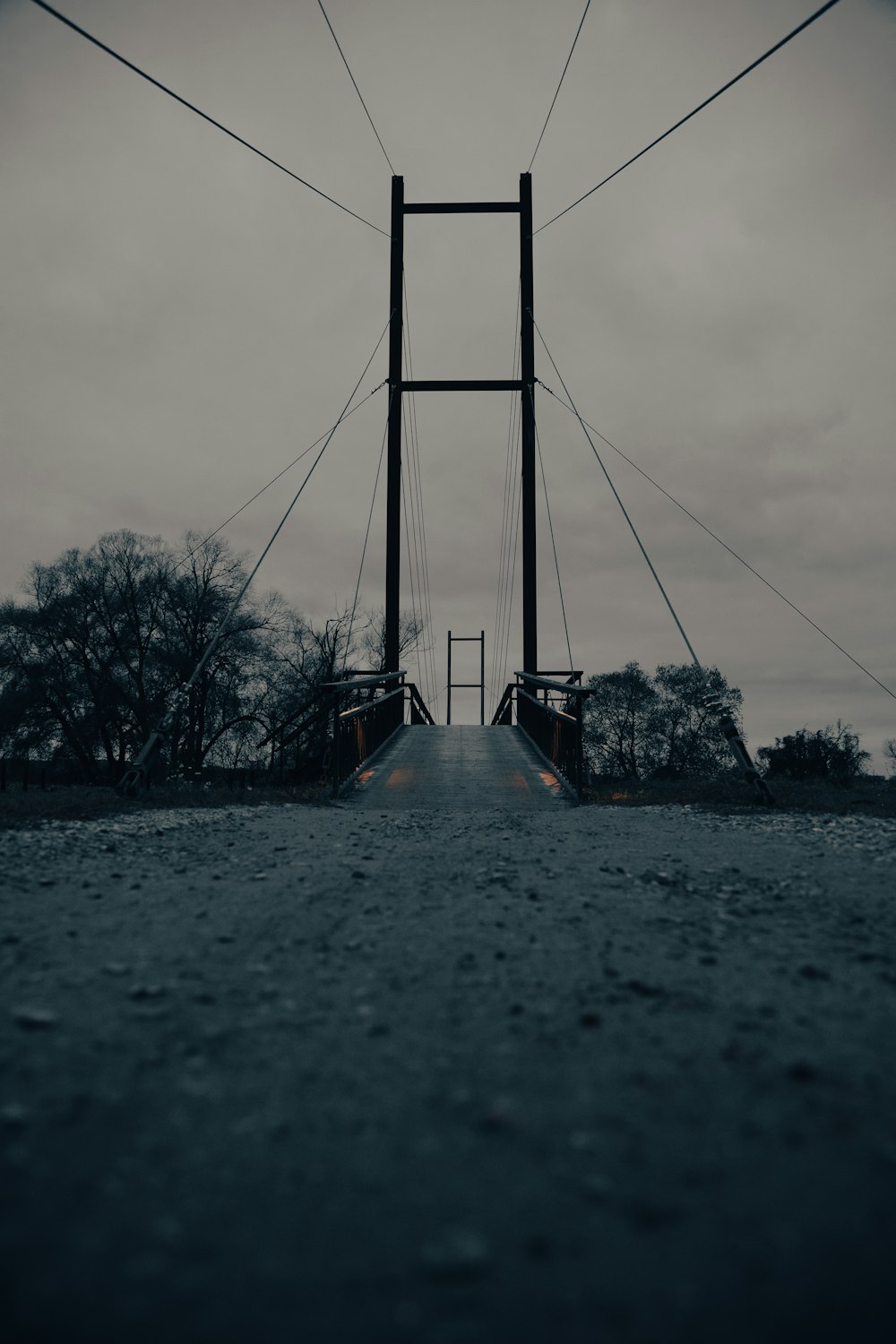 a long suspension bridge with trees in the background