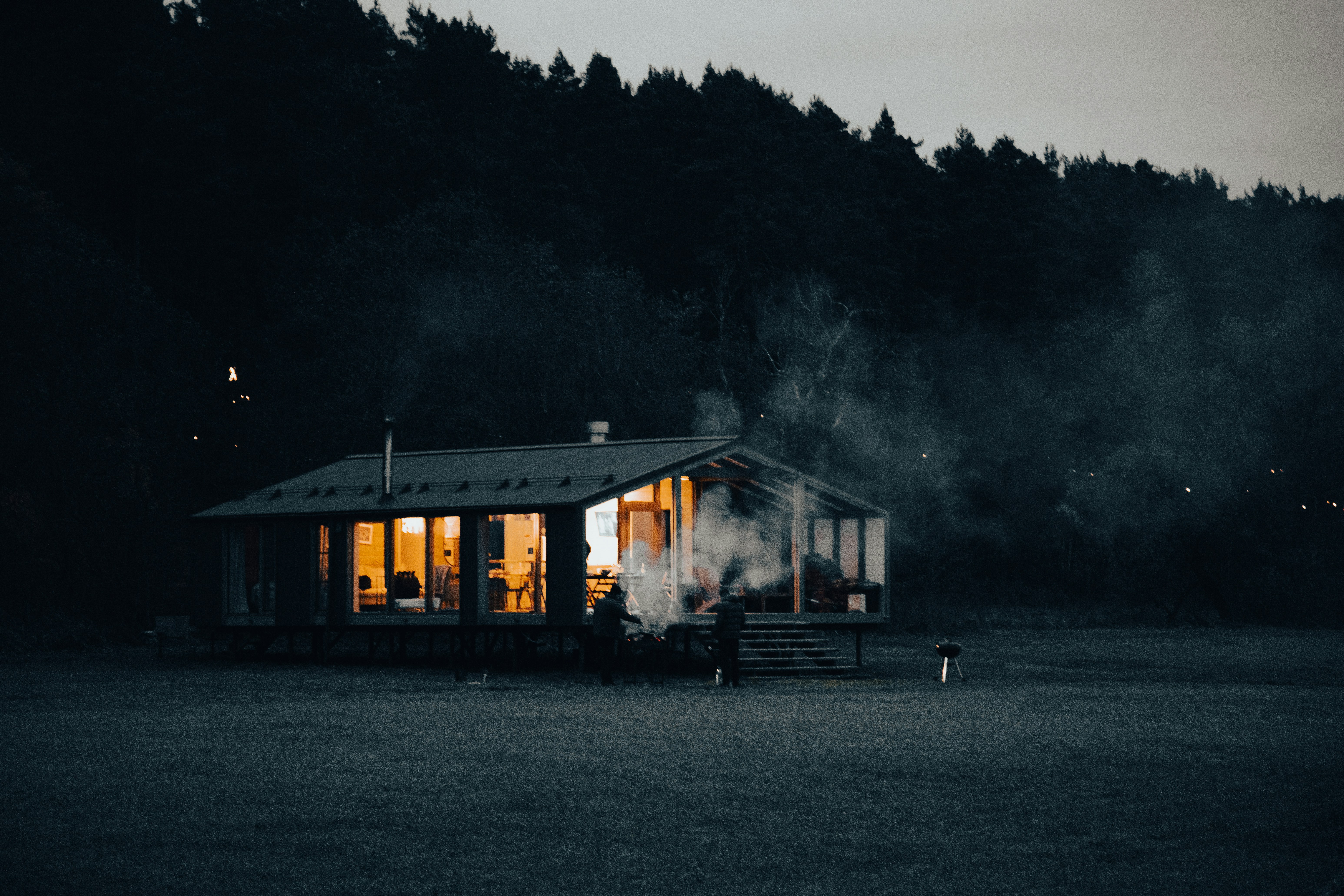a small cabin lit up at night in a field