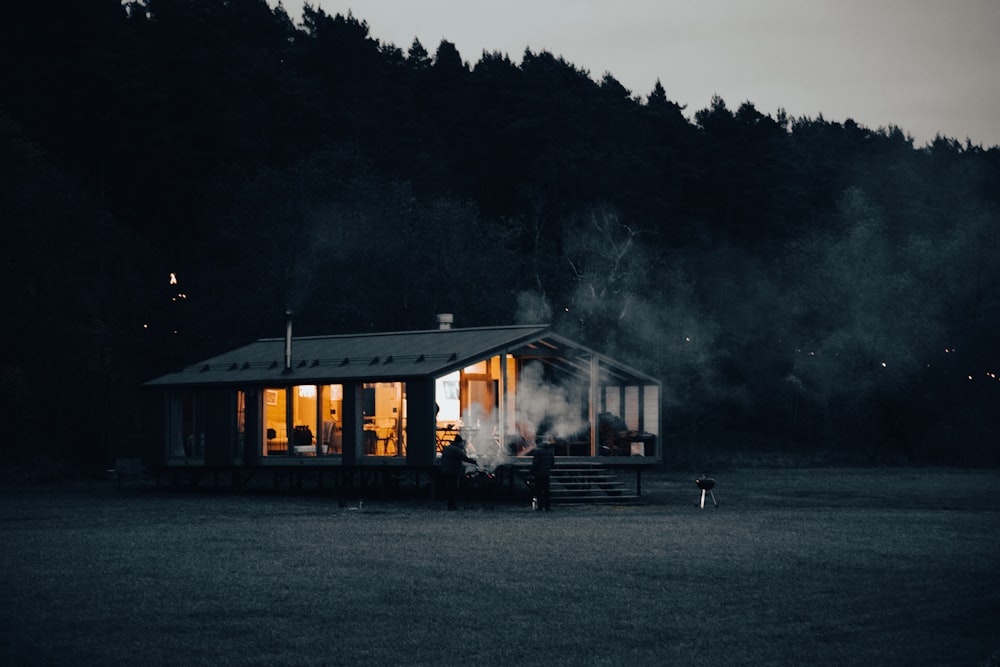 a small cabin lit up at night in a field