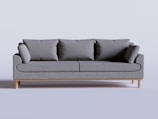 A stylish sofa with plush cushions in a bright, minimalistic room.