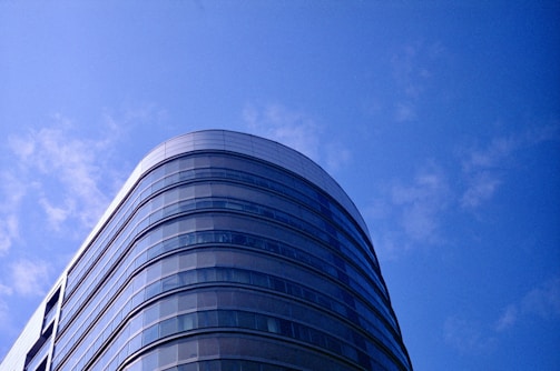 A panoramic view of the Inar Building's sleek glass facade reflecting the Cebu skyline on a sunny day.