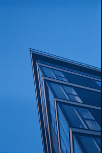 A sleek gold-accented modern building reflecting sunlight against a clear blue sky.