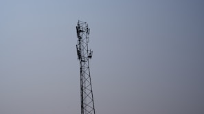 A telecommunications tower standing tall against a clear blue sky.