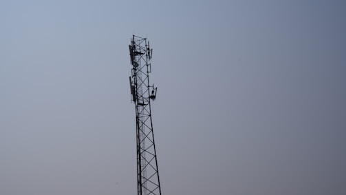 A modern telecommunications tower standing tall against a clear blue sky.