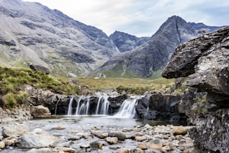 a small waterfall in the middle of a mountain stream