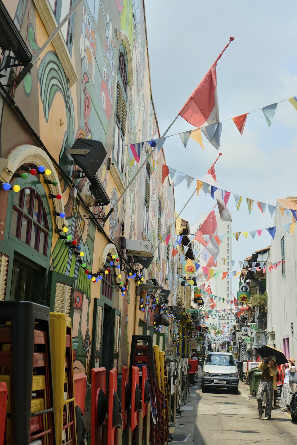 a city street lined with colorful buildings and flags