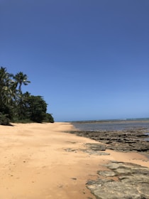 A serene view of the private beach accessible from the hotel, with golden sand and calm waves.