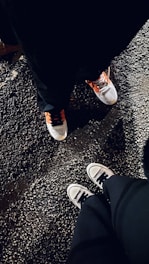 A pair of sleek sneakers resting on a city sidewalk at dusk.