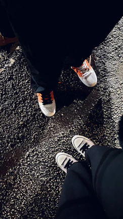 A pair of bold sneakers resting on a city street at dusk.