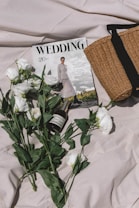 a bouquet of flowers and a magazine on a bed