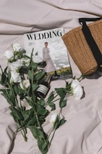 a bouquet of flowers and a magazine on a bed