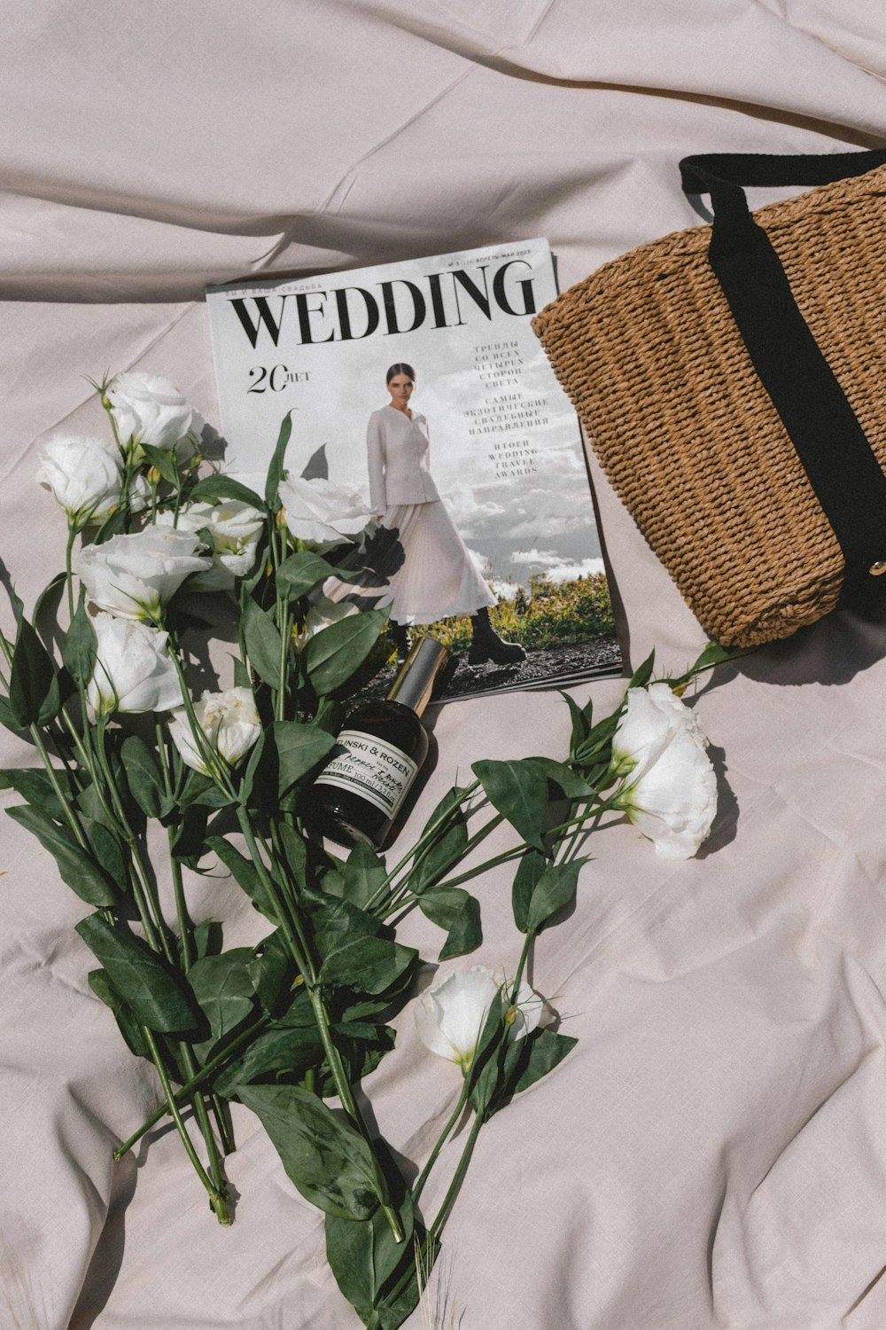 a bouquet of flowers and a magazine on a bed