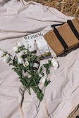 A bride and groom flipping through their personalized wedding magazine on a rustic wooden table.