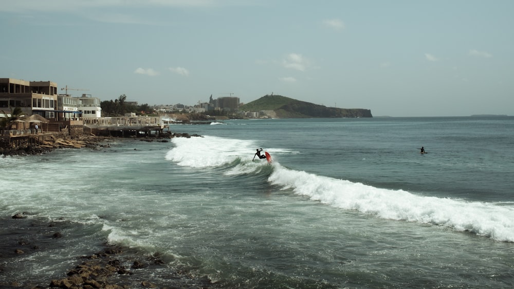 a man riding a wave on top of a surfboard