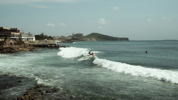 A man riding a wave on top of a surfboard — Dakar, Senegal