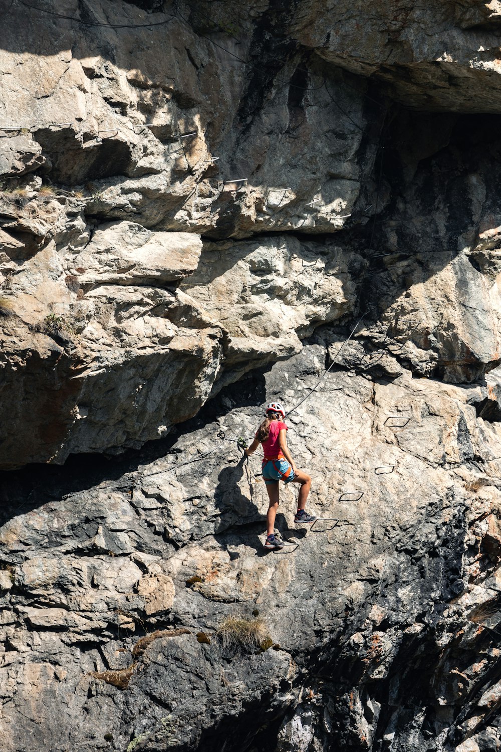 a person climbing up a rocky cliff