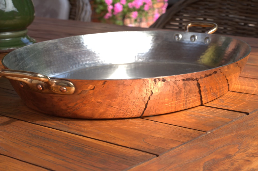 a large metal pan sitting on top of a wooden table