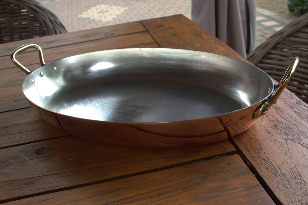 a large metal pan sitting on top of a wooden table