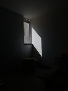 a dark room with a light coming through a window
