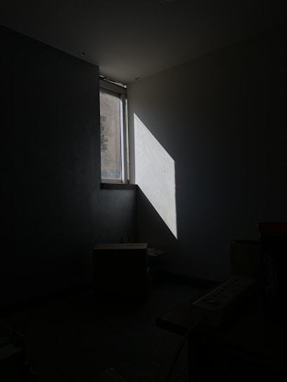 a dark room with a light coming through a window
