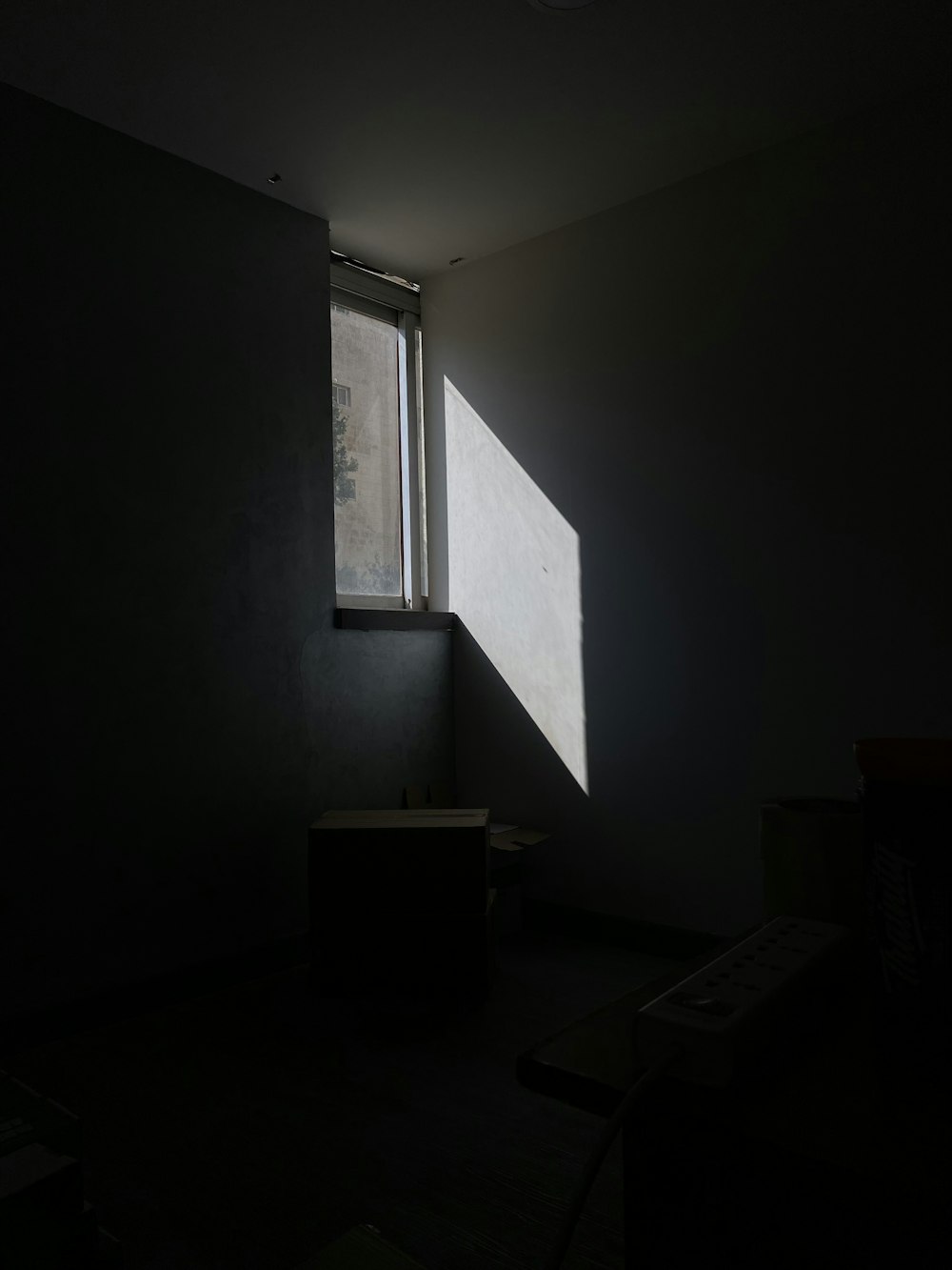una stanza buia con una luce che entra da una finestra