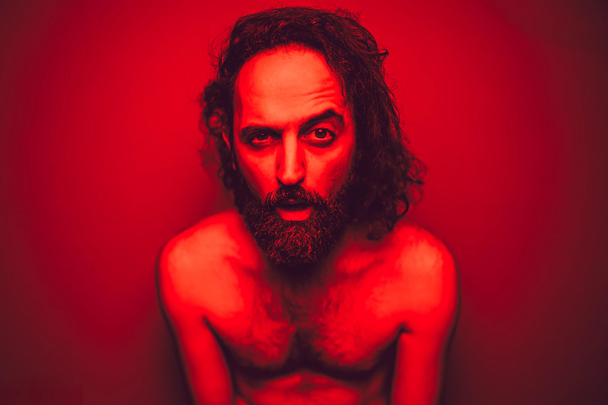 a shirtless man with long hair and a beard