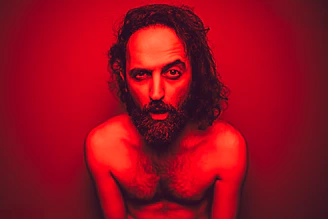 a shirtless man with long hair and a beard
