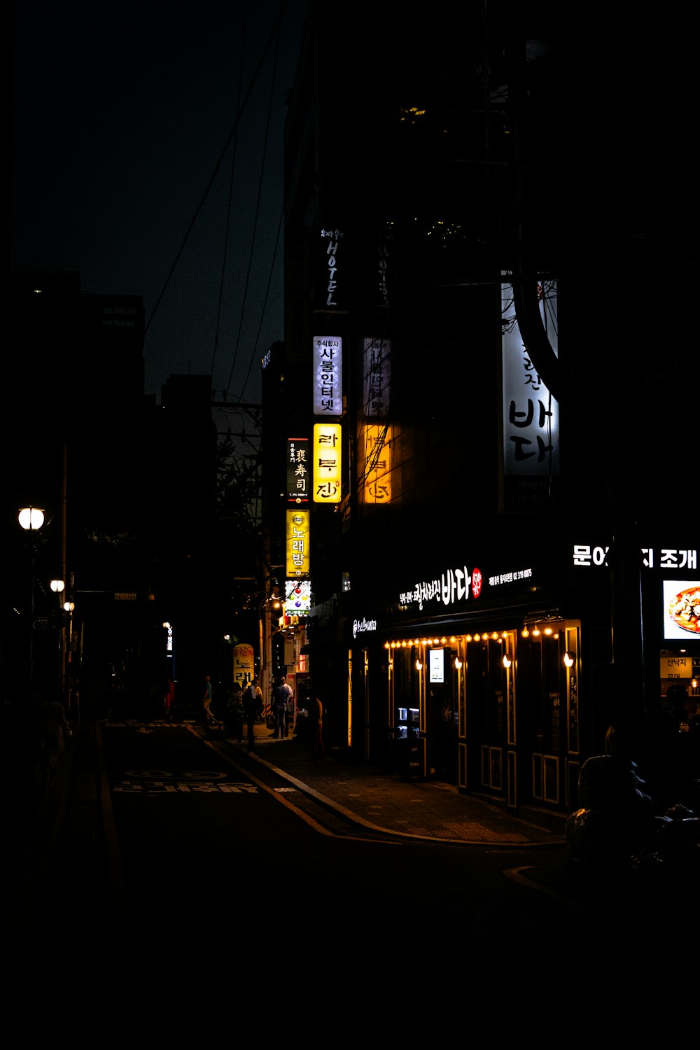 a dark city street at night with neon signs
