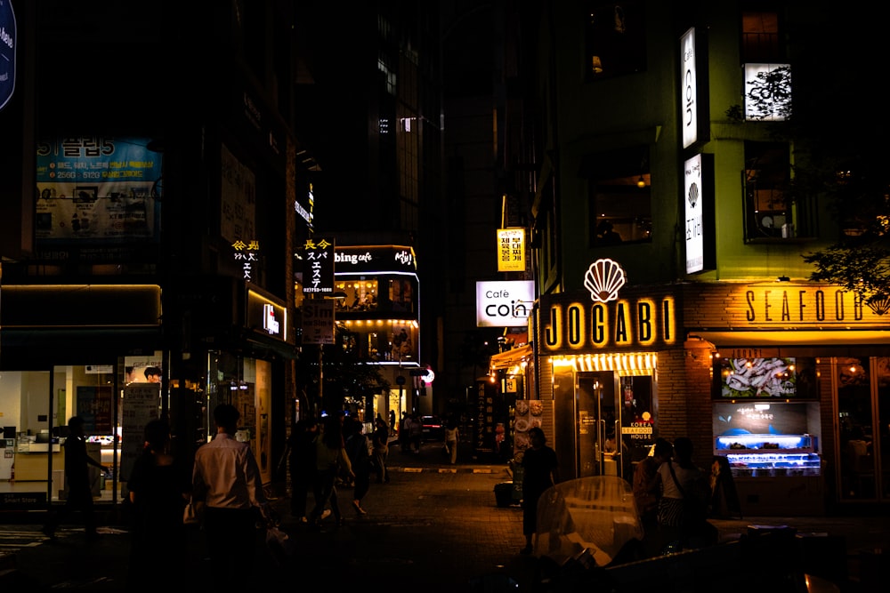 a city street at night with neon signs