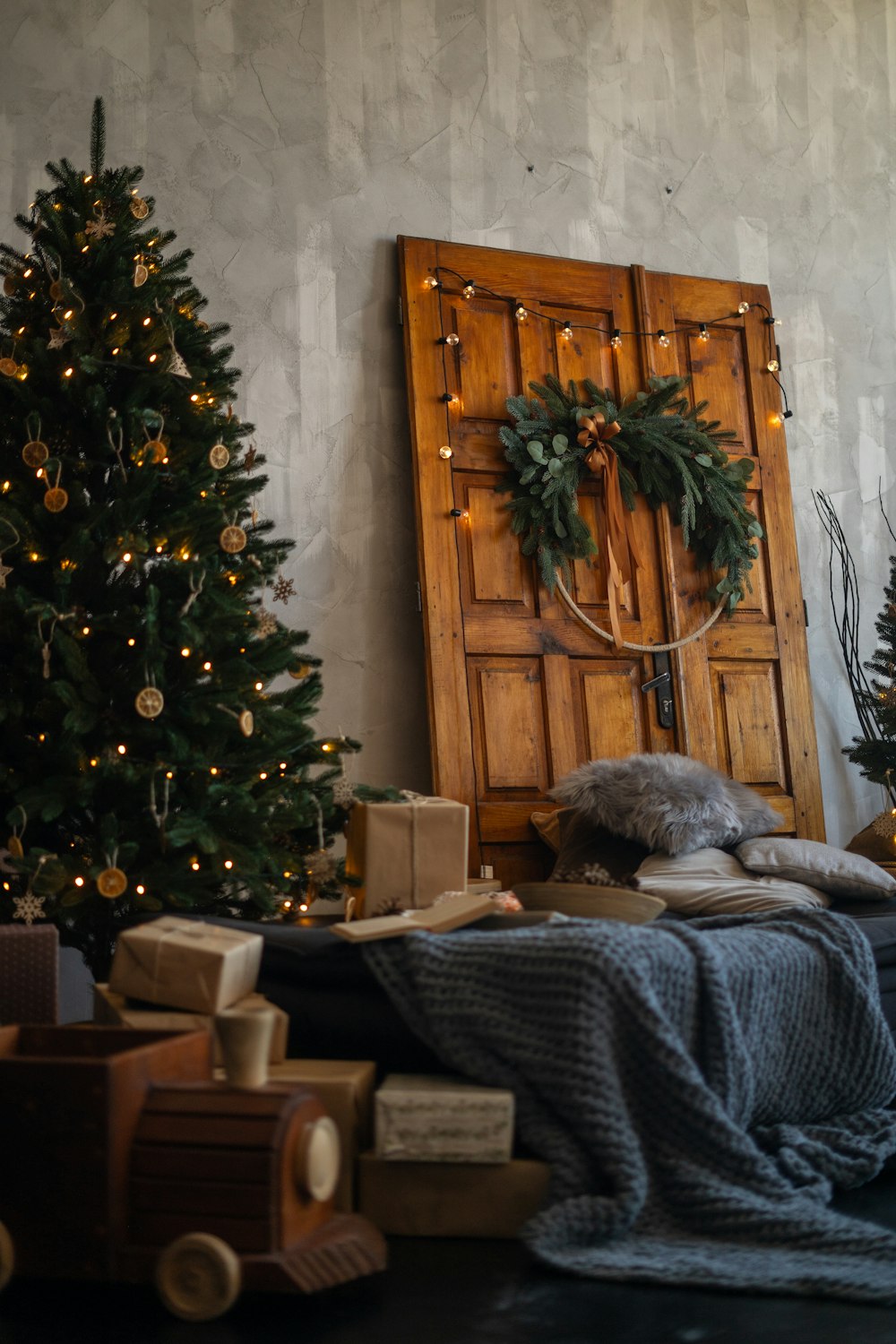 a christmas tree and presents under a wooden door