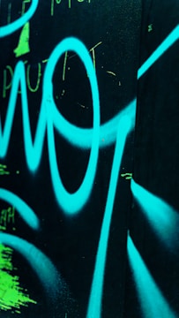 Alien graffiti sprayed across a muted silver wall with neon highlights.