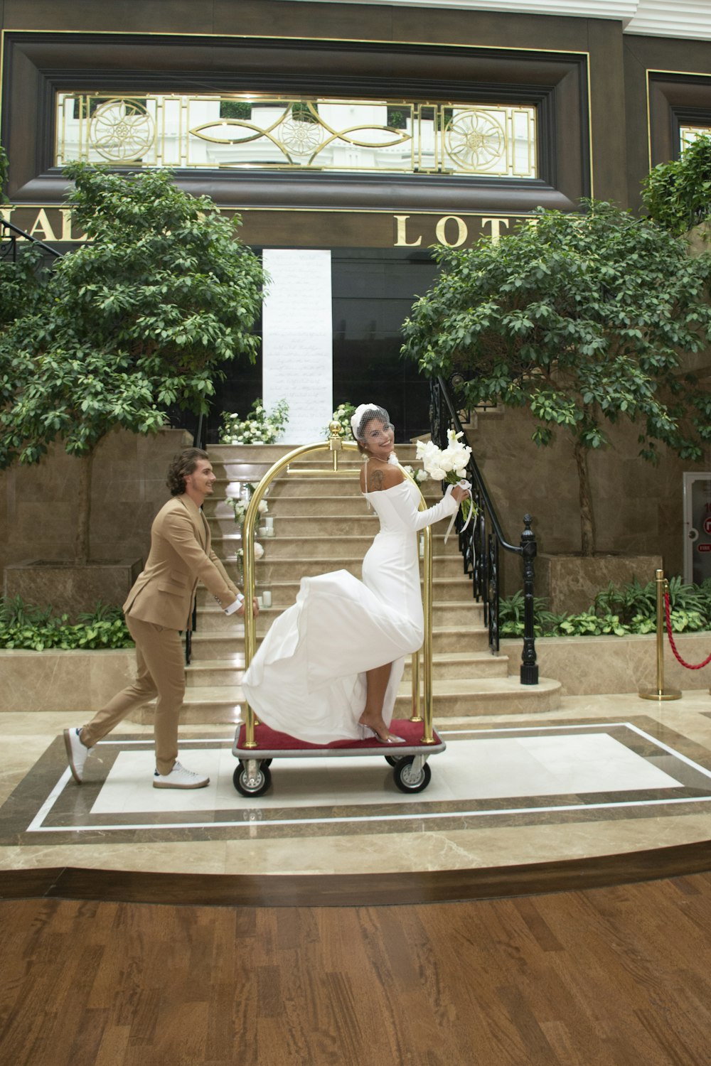 a woman in a white dress is pushing a hand cart