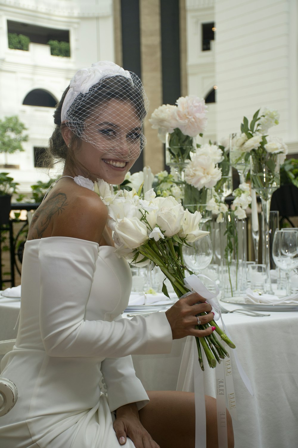 a woman in a white dress holding a bouquet of flowers